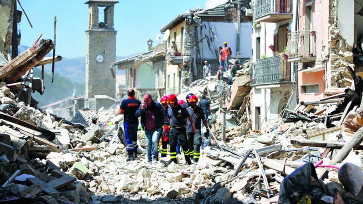 Rescatistas buscan sobrevivientes. Al fondo, el campanario del siglo XII.
